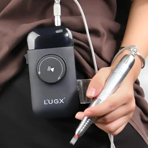 Vue réaliste de la ponceuse ongles portable L’UGX accrochée à la ceinture pendant une prestation.